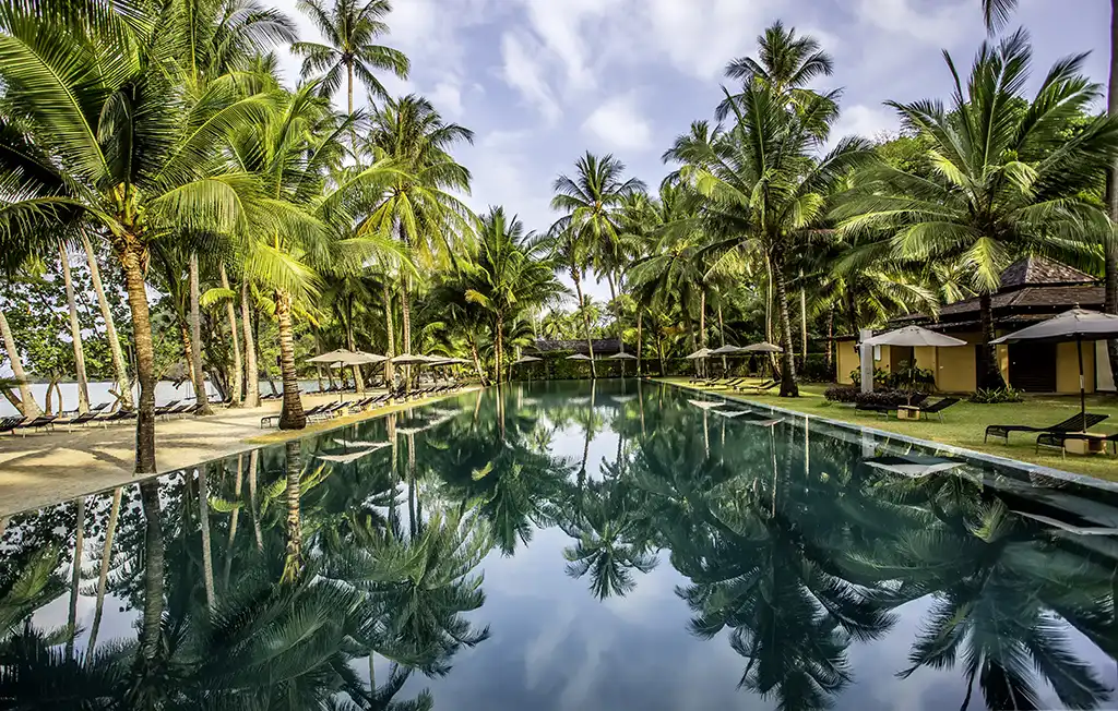 40-metre beachfront infinity pool surrounded by tropical palm trees at Blue Haven Bay, Koh Chang, Thailand